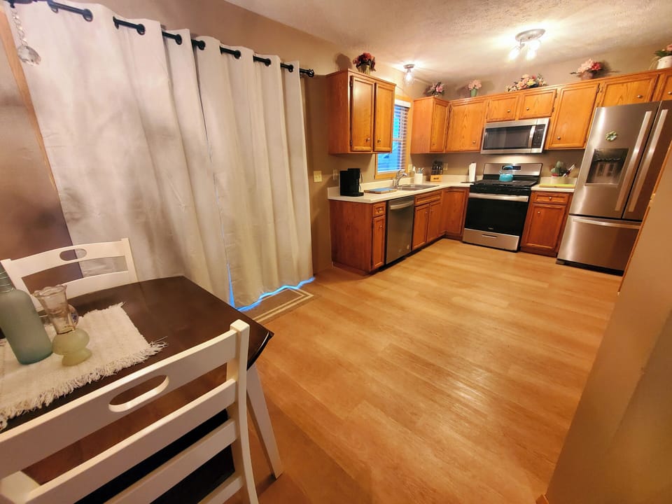 Fully equipped kitchen with new stainless appliances and drop leaf table.