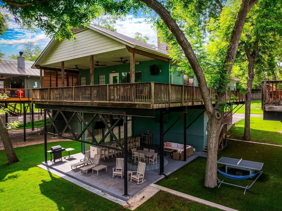 Two-story waterfront retreat with spacious outdoor living areas perfect for gathering and relaxing.
