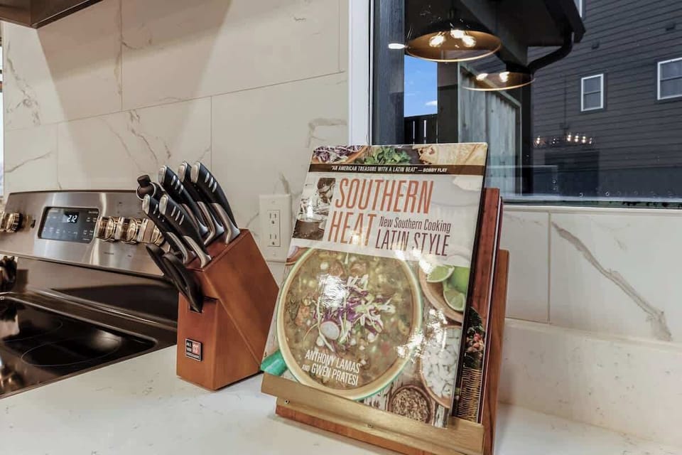 Modern kitchen countertop with a knife set and a southern cooking cookbook on display.