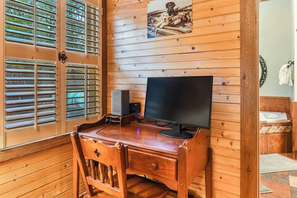 Cozy wooden workspace with natural light and a computer setup.