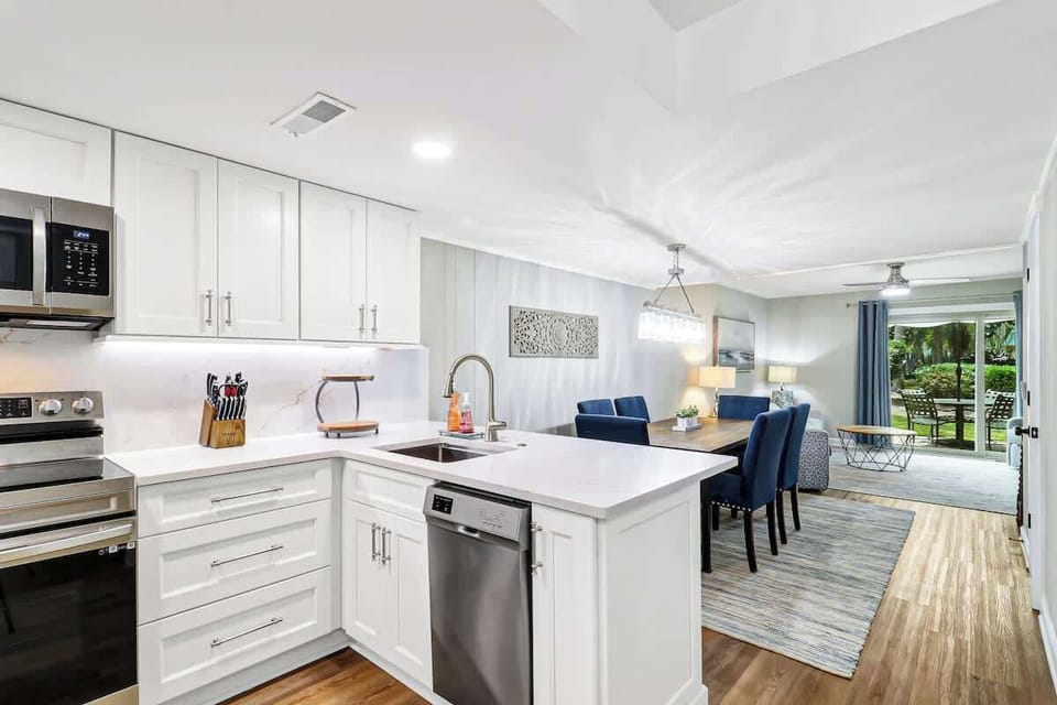 Step into your modern open-concept haven where crisp white cabinets and sleek appliances make cooking a joy.
