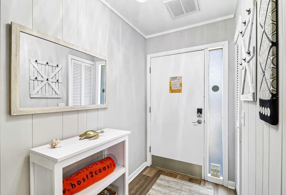 Entryway with a large mirror and coastal decor accents
