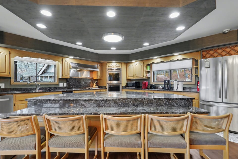 Large island kitchen with seating, double ovens, and prep space for groups