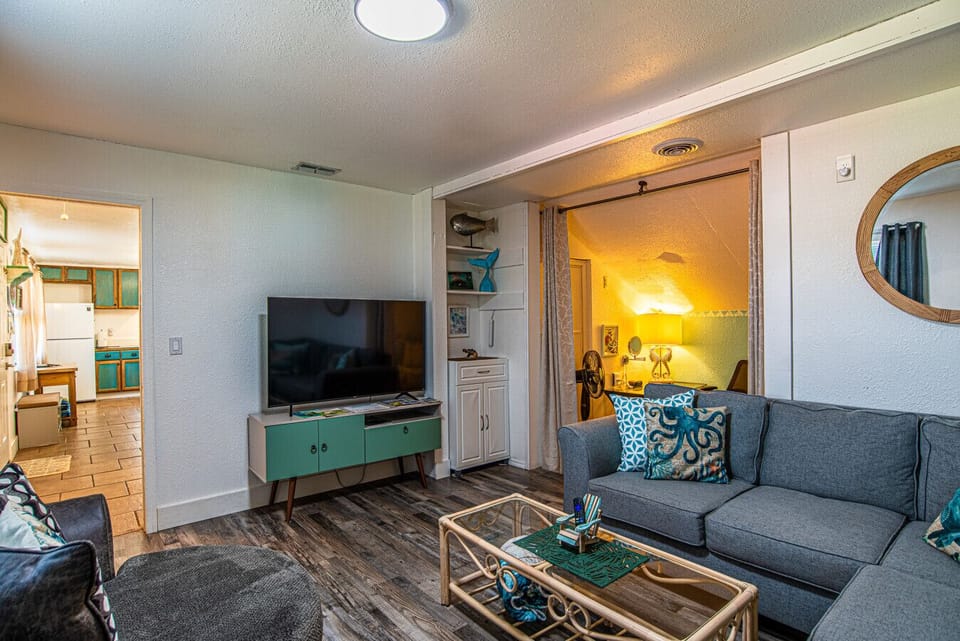 Living area with tv, entry to office/daybed and trundle room.