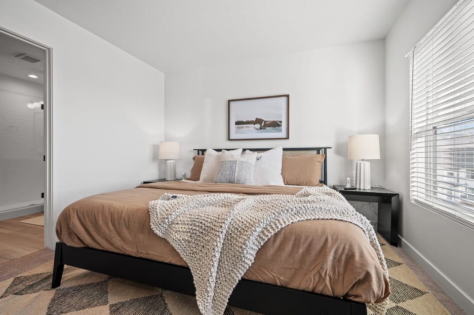 The primary bedroom boasts a plush king bed adorned with luxurious linens and pillows for ultimate comfort.