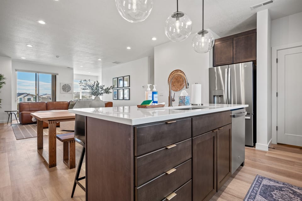 With its modern lighting, windows, quartz countertops, and stunning backsplash, the kitchen makes preparing dinner a truly enjoyable experience.