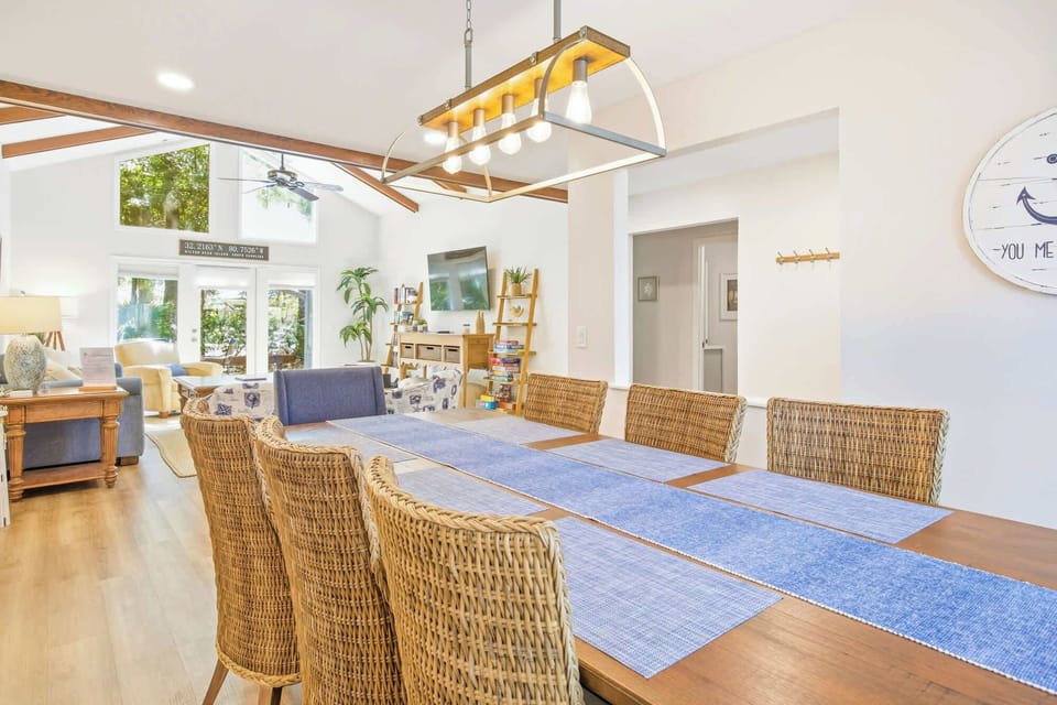 Spacious dining area with wicker chairs and natural light from large windows