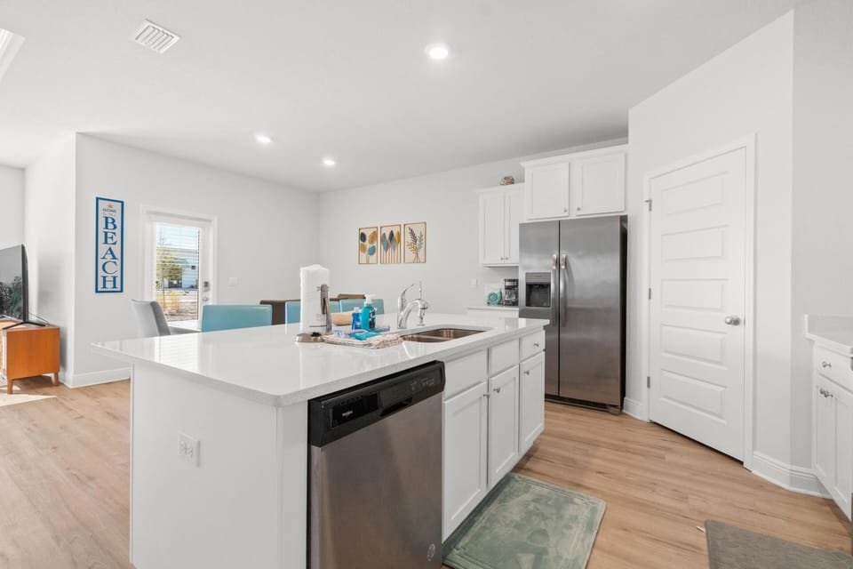 Your fully equipped kitchen features modern appliances and a spacious island, perfect for preparing meals during your beach getaway.
