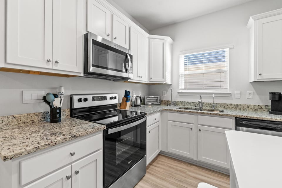 Cook your favorite meals in this bright, fully-equipped kitchen featuring granite counters, stainless appliances, and plenty of cabinet space.