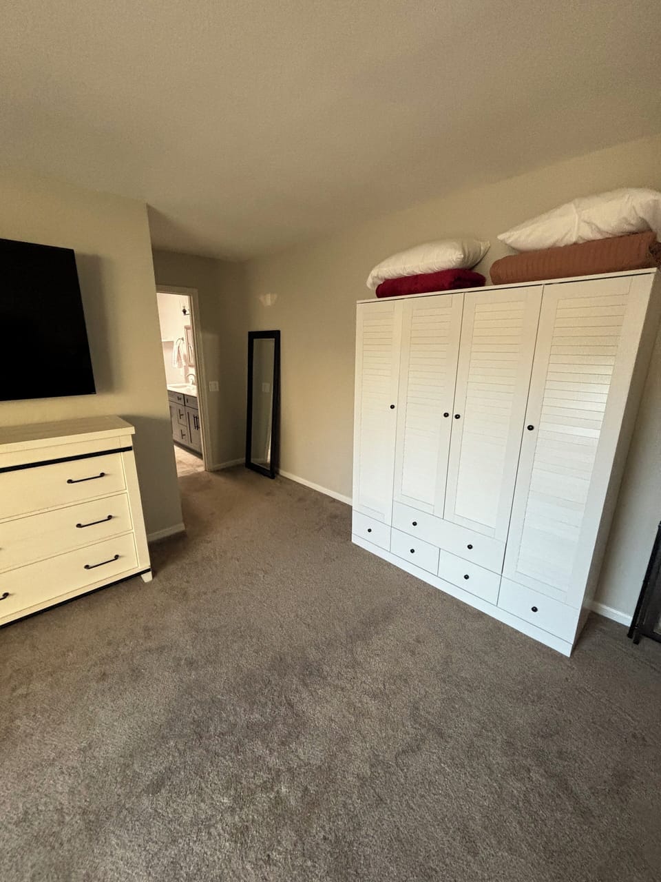 Large wardrobe for hanging clothes or storing in drawers. Extra bedding above.