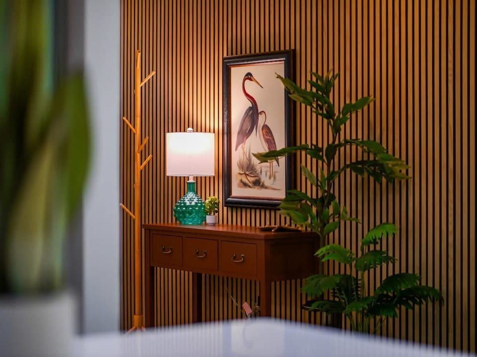 Tropical-inspired decor corner w/ wood paneling & lush plant touches