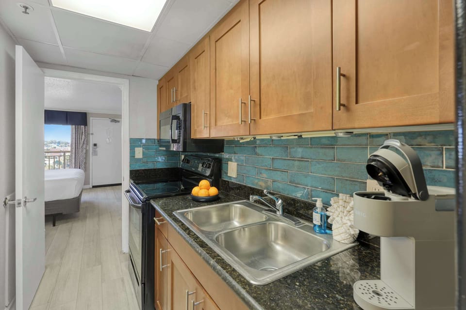 This fully stocked galley kitchen makes vacation cooking easy, with sleek appliances, granite counters, and a coffee maker to kickstart your mornings. Enjoy comfort and convenience just steps from the beach.