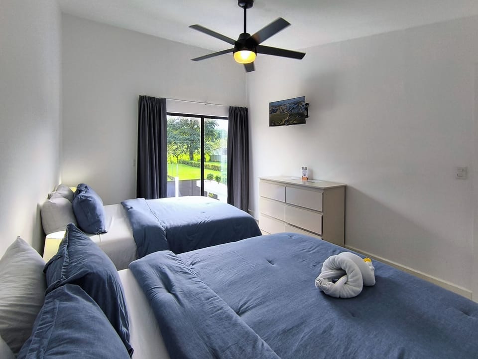 Bedroom 2: Two queen beds, smart TV and A/C unit. 