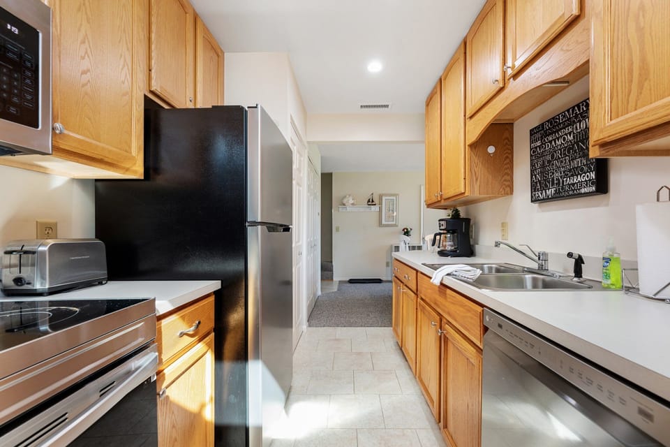Galley kitchen w/ warm wood cabinets & ample counter space for easy meal prep