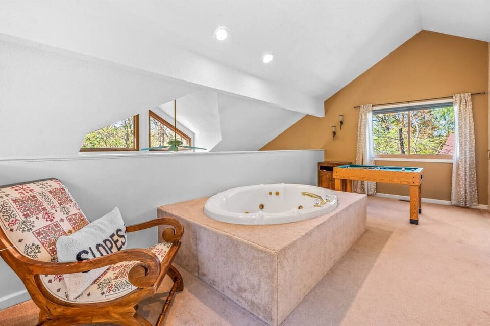 The upstairs area includes a large jacuzzi soaker tub and a bumper pool table, along with the sauna.