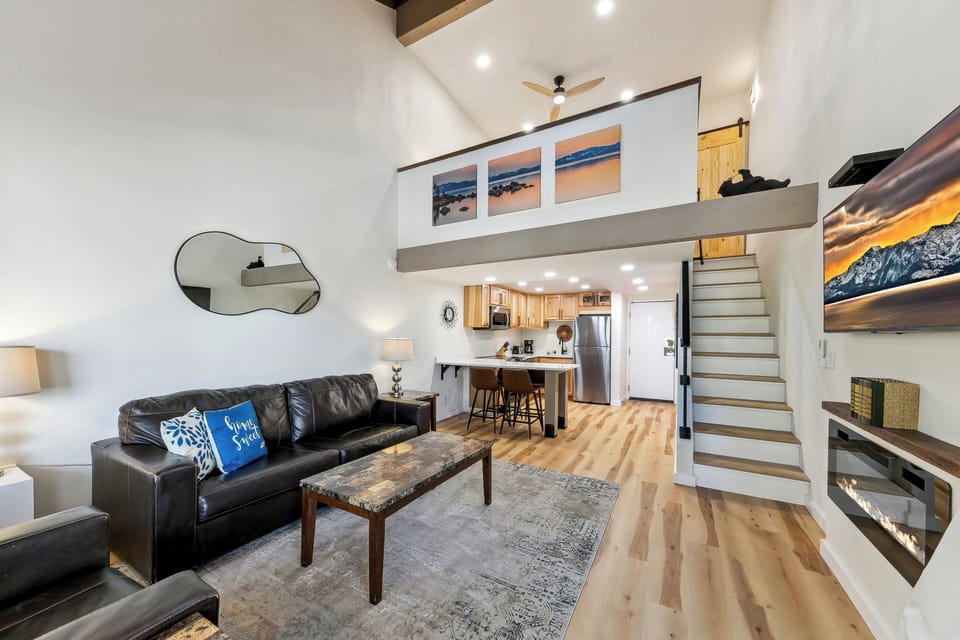 Your stylish loft features soaring ceilings, gleaming hardwood floors, and a cozy leather sofa perfect for unwinding after exploring.