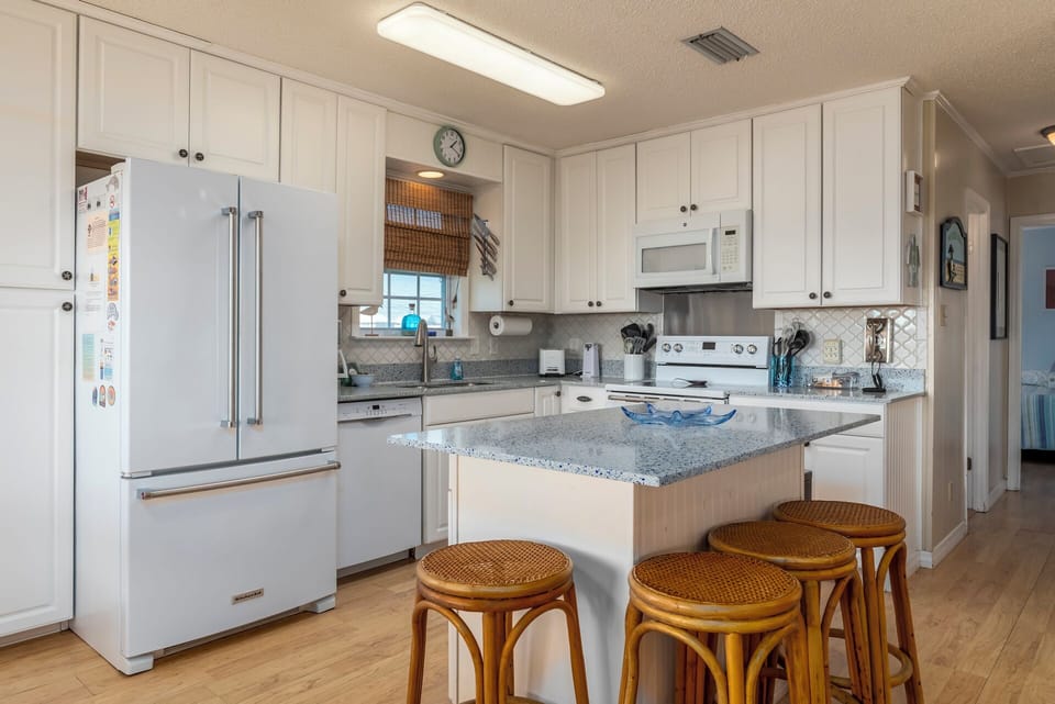 Your bright kitchen features granite counters, modern appliances, and a breakfast bar perfect for casual dining.