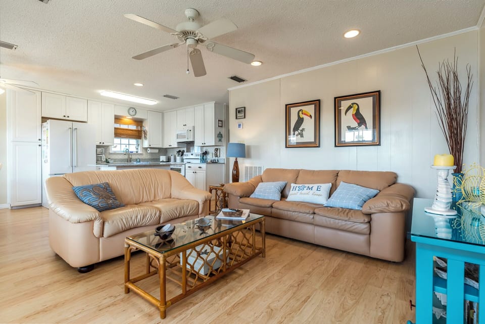 Relax in your spacious open-plan living area with comfortable leather seating, modern kitchen, and tropical touches that make you feel instantly at home.