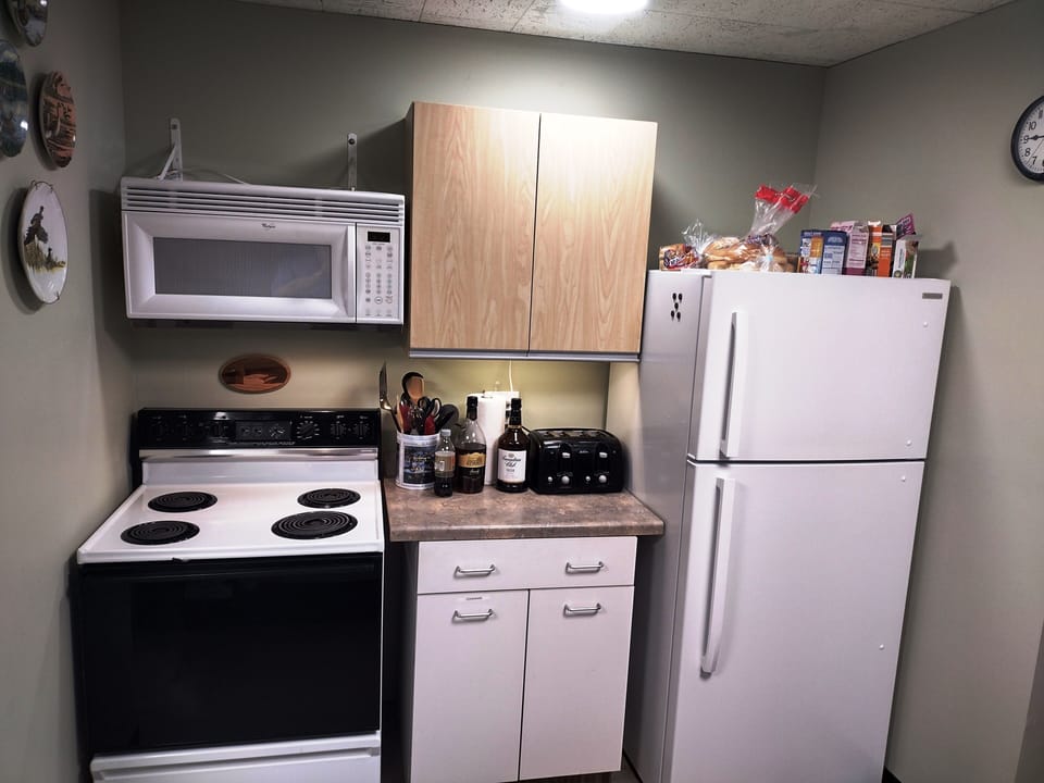 Part of kitchen showing stove, microwave and refrigerator.