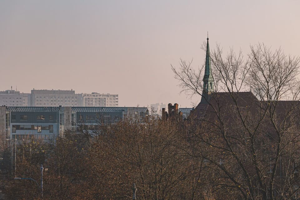 A breathtaking view of Poznań from the apartment at sunset. Streets, majestic churches, and modern skyscrapers come together to create an unforgettable cityscape.