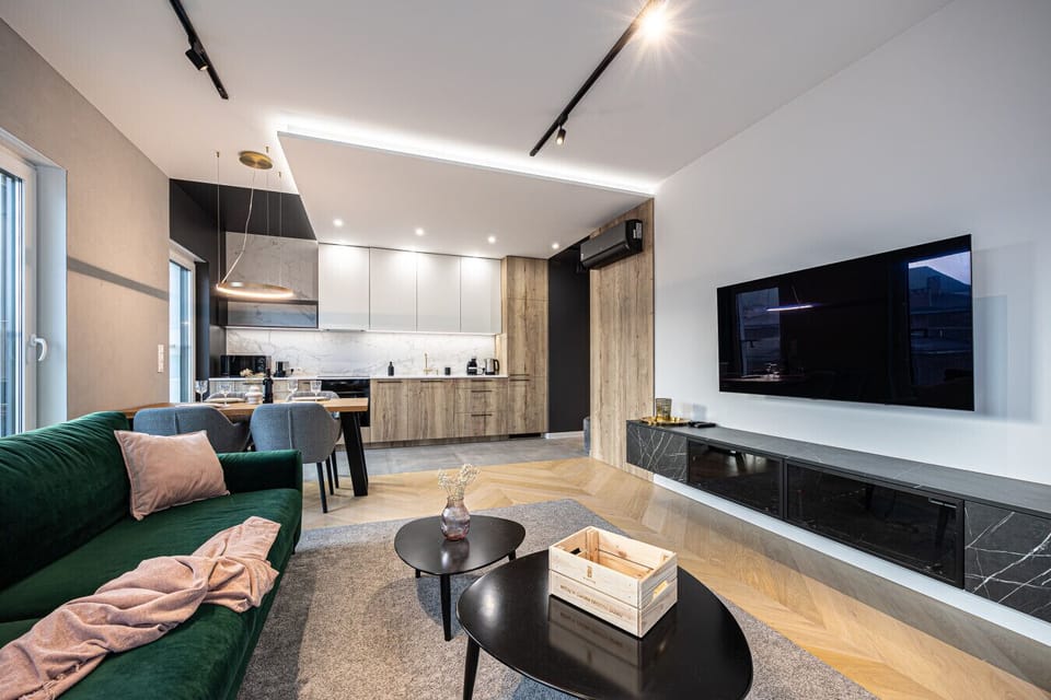 A view of the spacious living room leading to a stylish kitchenette and dining area. The perfect space where relaxation seamlessly blends with the comfort of cooking and shared meals.