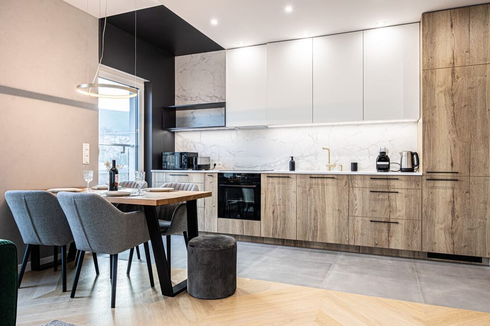A view of the spacious living room leading to a stylish kitchenette and dining area. The perfect space where relaxation seamlessly blends with the comfort of cooking and shared meals.
