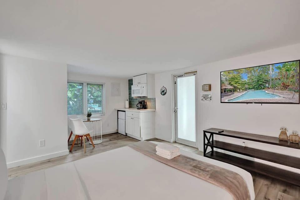 Studio bed with kitchen and pool-view TV in background