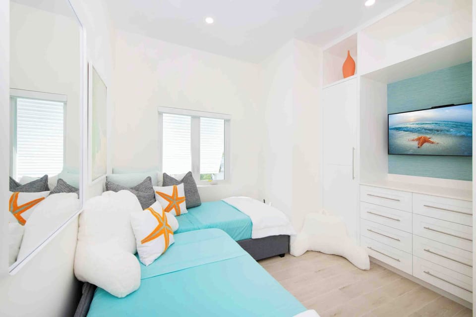 Bedroom 4 on the upper level furnished with two twin beds and an HD television. 