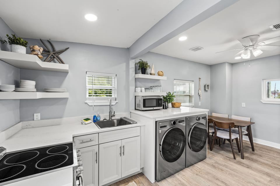 Fully equipped kitchen at The Lookout at R½ — full-size stove, in-unit washer and dryer, open shelving, and a dining area for the whole group. Built for longer stays.