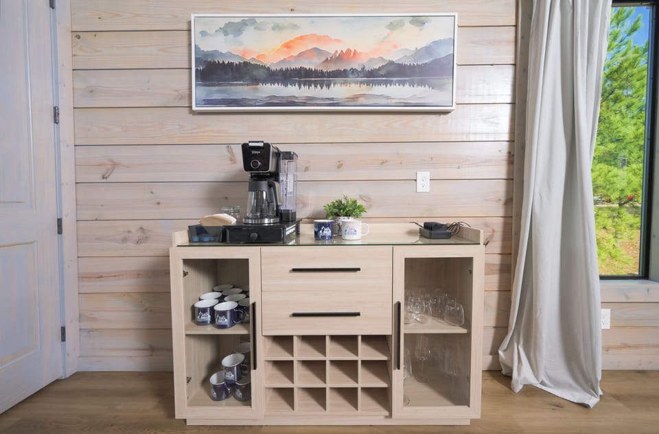 Our coffee bar is stocked with pods for coffee and tea, grounds, creamer and sugar. Wine glasses, both stem and stemless, are stored on the right side. 