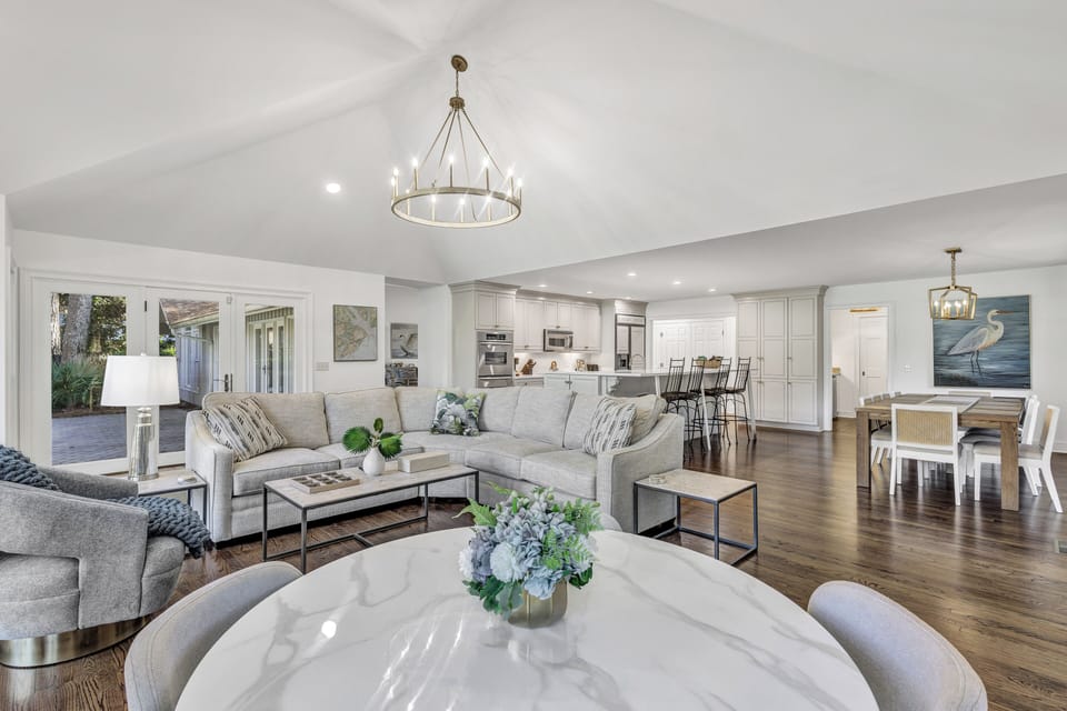 Expansive Living: Bright, open layout with panoramic windows framing the private pool deck and wooded golf course views.