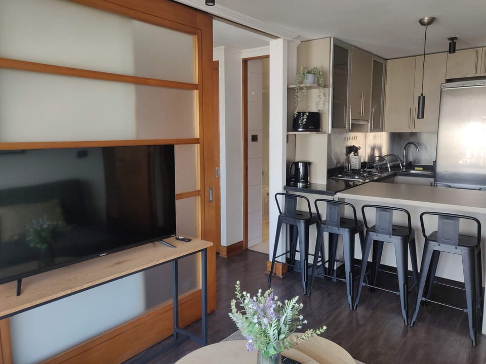 Modern kitchen with sleek appliances and cozy seating, perfect for enjoying meals and entertainment.