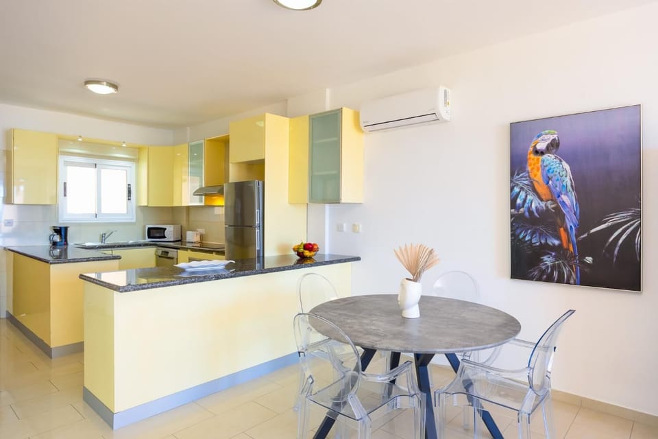 A detailed view of the dining and kitchen zone, emphasizing the vibrant accent pieces and modern textures used in the open-concept layout.