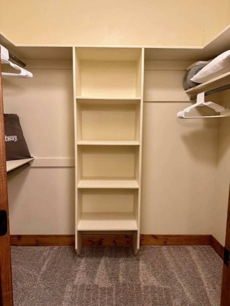 Master bedroom walk in closet; hangers and extra blankets, pillows