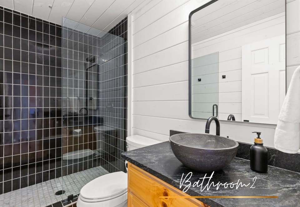 Stone sink and modern touches make this bathroom both functional and stylish.