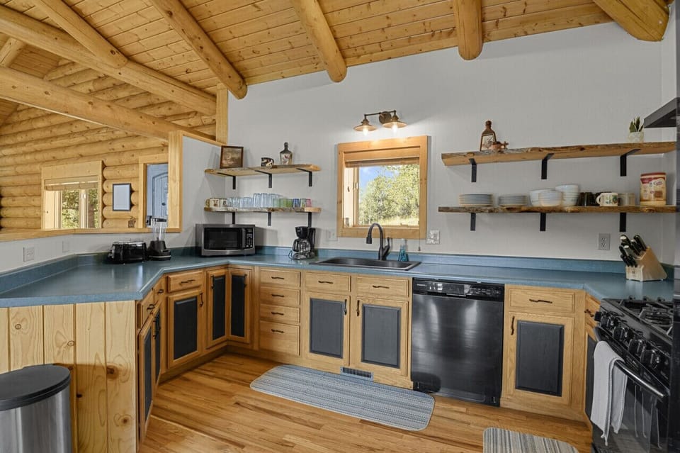 Kitchen stocked with cookware, gas stove, fridge and dishwasher
