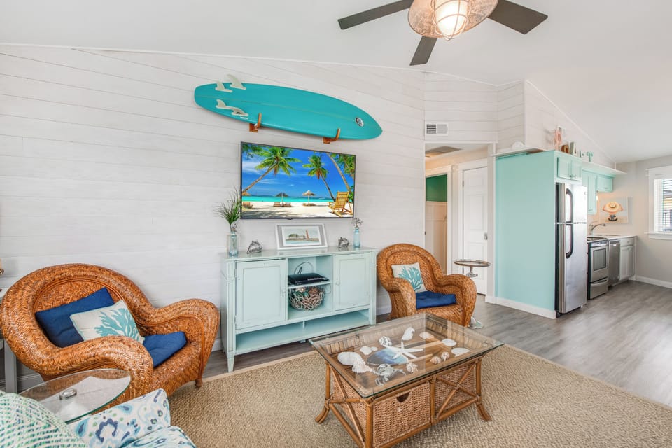 Your coastal retreat features wicker seating, beach-themed decor, and an open kitchen perfect for relaxing after sandy adventures.