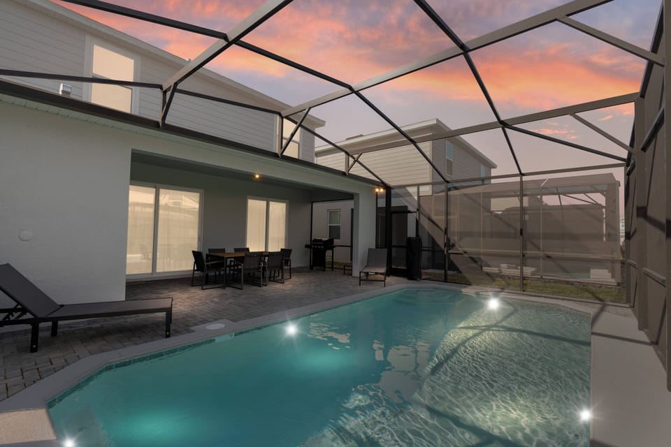 Step outside to your private oasis with a sparkling pool and stylish patio furniture, ideal for sunset lounging. The modern design features a beautiful mesh enclosure, enhancing your seamless indoor-outdoor living experience.