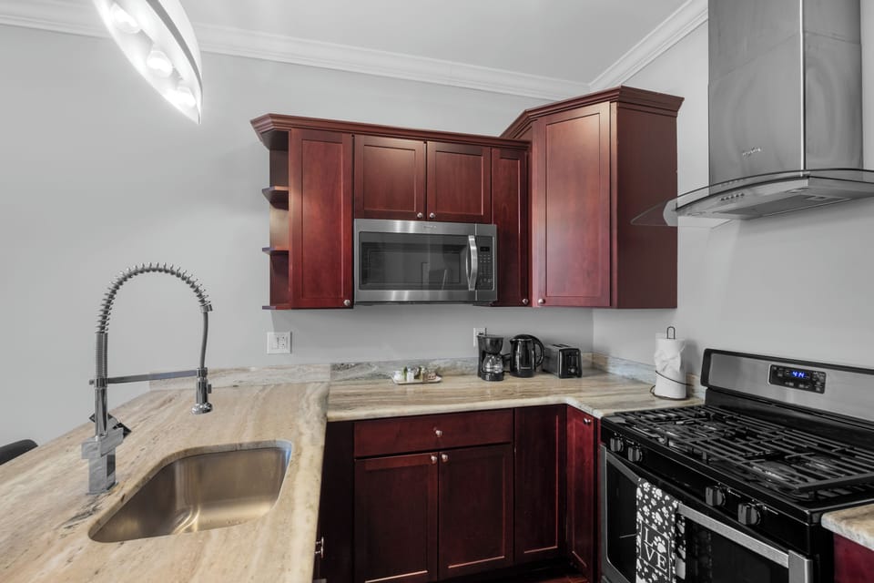 Full kitchen with stainless appliances, cherry cabinets, and complete cookware providing all the tools for delicious meals.