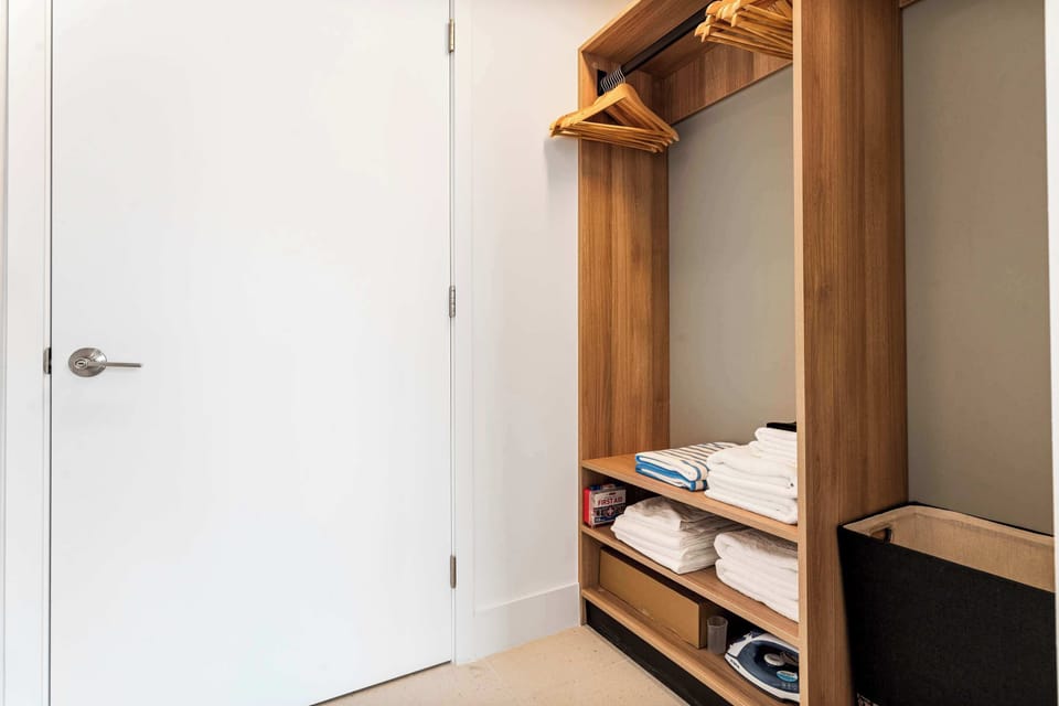 Generous open closet organizer with shelving and hanging space for all your luggage and wardrobe needs.