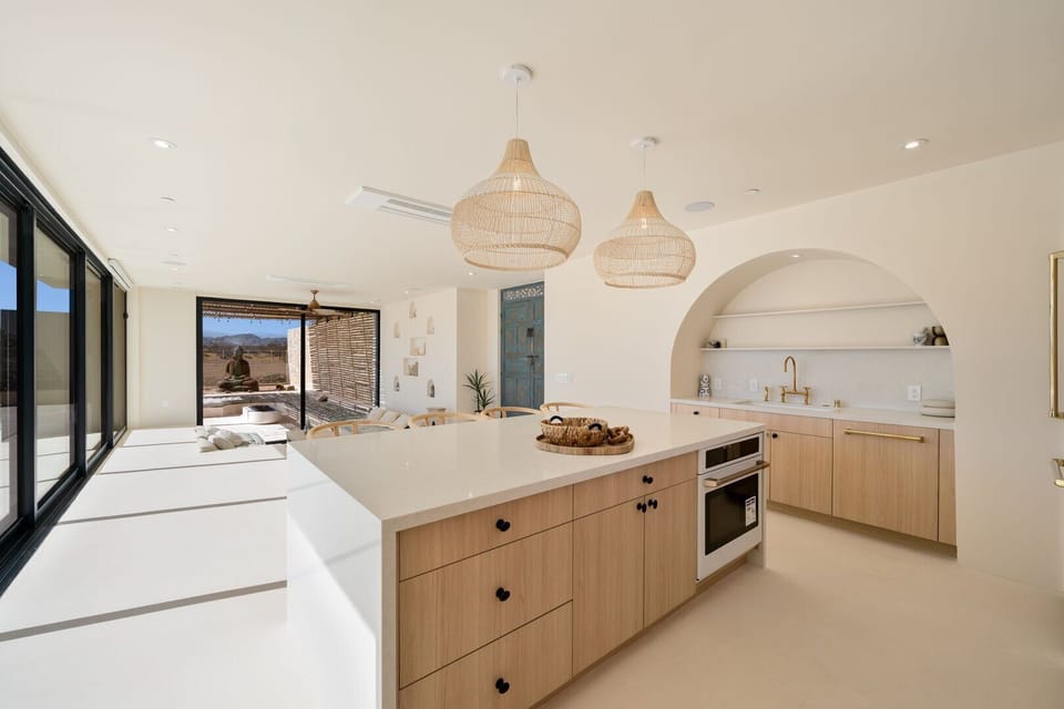The kitchen looks out to the sunken living room and outdoor entertainment area.