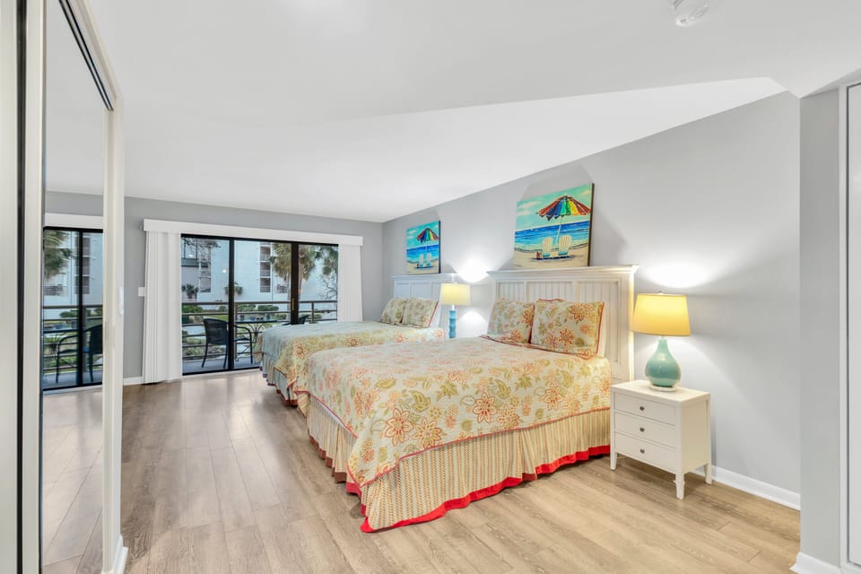 Bedroom 2 – Guest Suite: Two Queen-size beds with premium linens, Ensuite with walk-in shower and a 65" smart TV