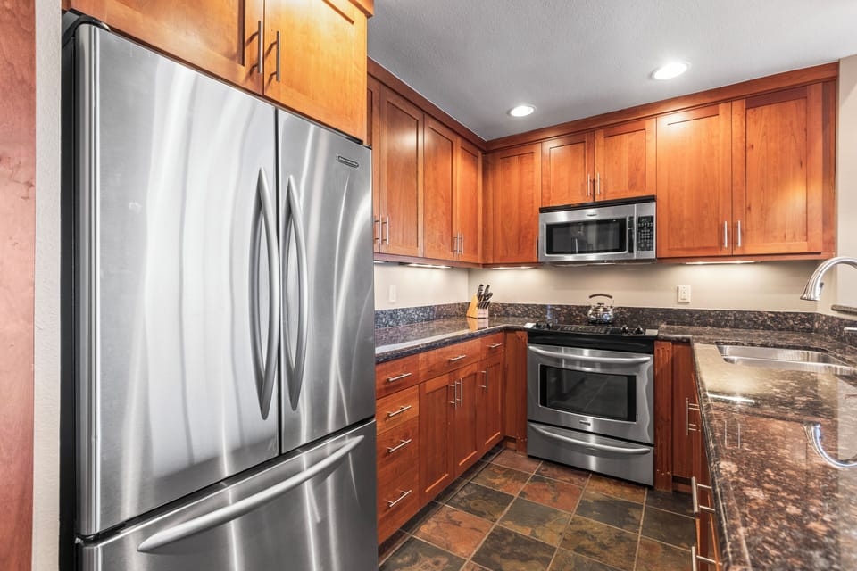 The well-equipped kitchen has stainless steel appliances and rich wood cabinetry.