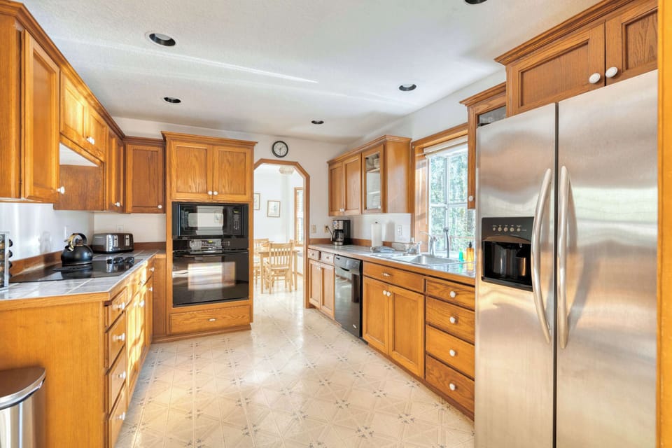 Kitchen with range, fridge, and cabinet storage.