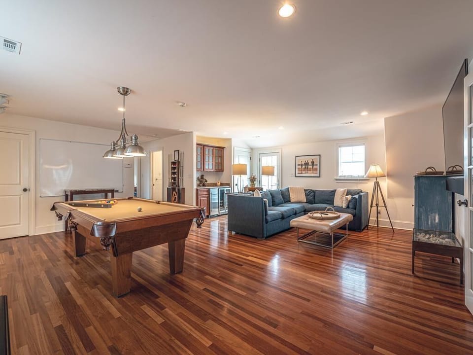 A secondary living area offers a comfortable retreat with plush seating and warm coastal décor.