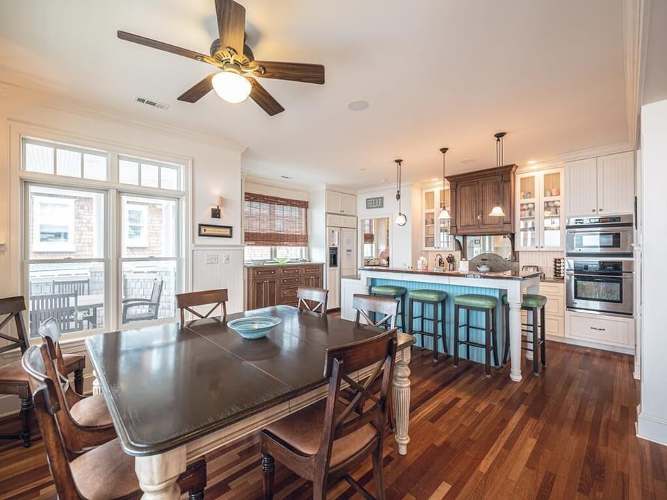 Spacious dining area and gourmet kitchen with a large island, stainless steel appliances, and ocean views—ideal for gathering over meals.