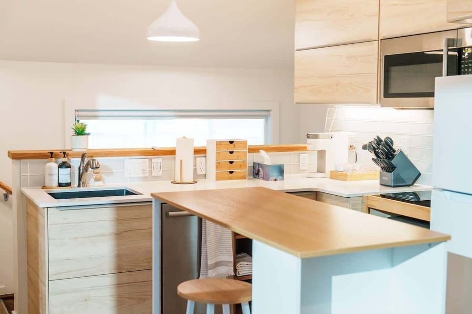 Compact kitchen with everything you need, plus a wood-top island and stools perfect for morning coffee, quick bites, or chatting while you cook.