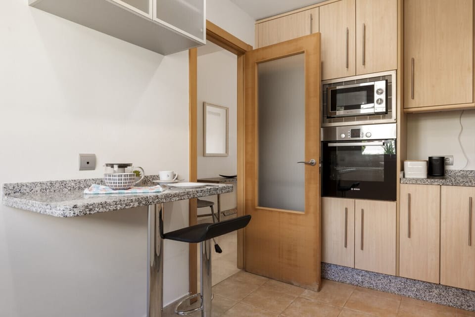 Fully-equipped kitchen with Nespresso coffee maker, oven, dishwasher, and washing machine