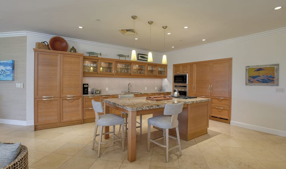 Gather in the dining and kitchen area of 21-6 Ho'olei, where modern elegance meets island charm