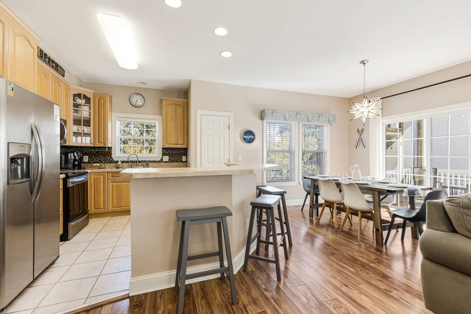 Spacious kitchen with dining table that has seating for 6, plus a breakfast bar with seating for 4.